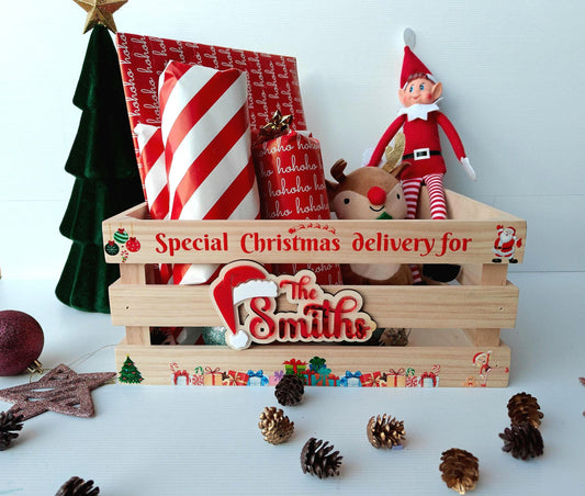 A rustic wooden Christmas Eve crate with slatted sides, personalised with a family name and 'North Pole Post' design on the front.
