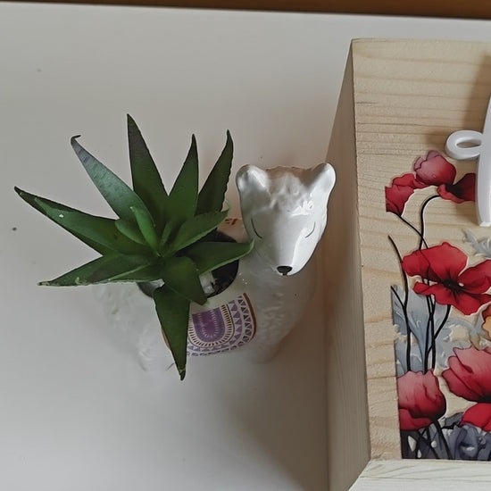 Wooden memorial box with the name 'Elizabeth Anne' engraved on the lid, shown with photos inside.